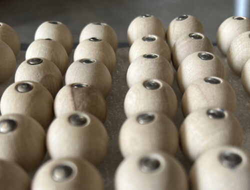 Binôme de boules de bois de charme prêtent au montage car rangées chacune avec une pointe dans un mousse